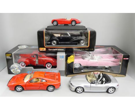 A box of die-cast including 1:18 scale Eagle's Race car and pink Maisto Cadillac 
