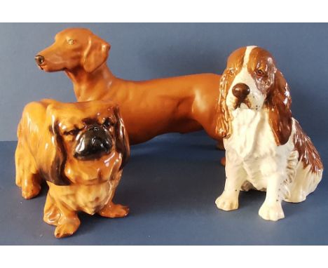 Three Royal Doulton Dogs to include :Pekingese 'Champion Biddee of Ifield' - No. 1012 in gloss - 3". Dachshund - No. DA116 in