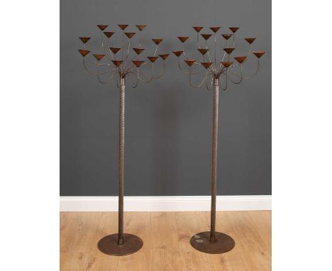 A pair of floor standing wrought steel fifteen light candelabras with cable twist stems and circular bases, each 146cm high t