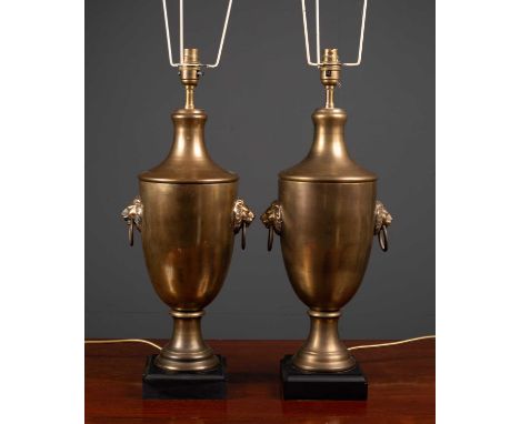 A pair of cast brass table lamps of urn form with lion mask ring handles and black painted square bases, 52cm high to the top