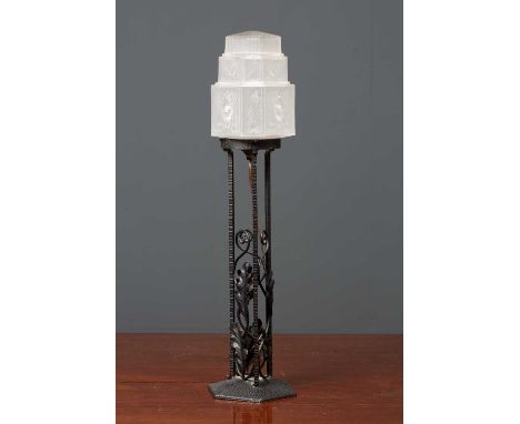 A wrought iron table lamp with oak leaf ornament and stepped art deco style frosted glass shade, 59cm wide together with an a