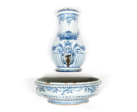 An 18th century French Rouen faience lavabo decorated in cobalt blue with half round baluster water vessel and basin beneath,
