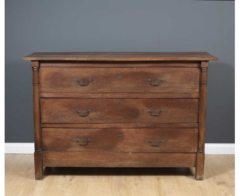 A 19th century French oak three drawer commode, the three drawers flanked by pilaster columns and with panelled sides with pe