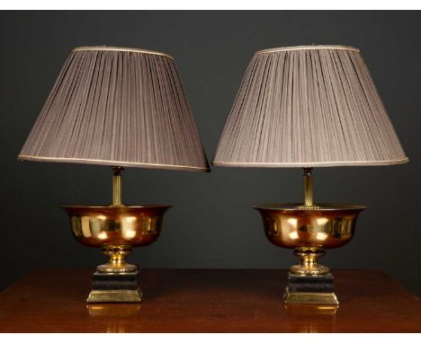 A pair of gilt metal and ebonised table lamps in the form of shallow urns on plinth bases, the table lamp bases 24.5cm diamet