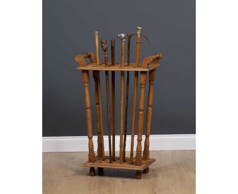 An oak stick stand for displaying walking sticks, with turned supports together with a group of six 19th century and later wa