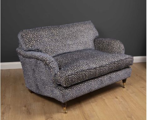 A small modern deep two seater sofa with turned front legs and brass casters, upholstered in lilac leopard skin upholstery, 1