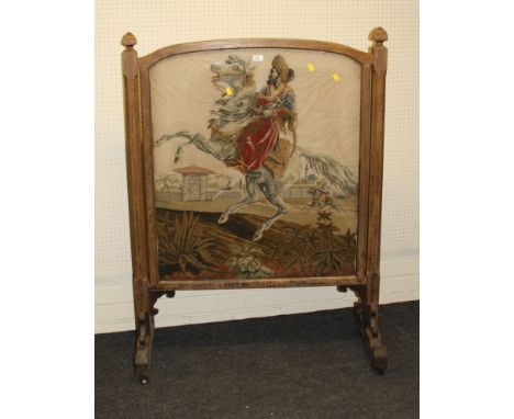 A Victorian oak country house firescreen, set with a gros point tapestry panel of a Turk on horseback, the slightly arched fr
