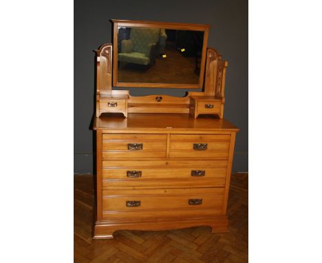 An Edwardian walnut dressing chest, the adjustable rectangular mirror within a pierced, tulip carved two drawer superstructur