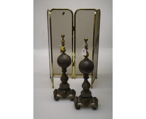 A pair of 19th century steel and brass fire dogs, each with globe shaft and a 20th century four panel smoked glass brass fram