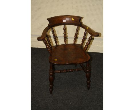 A 19th century oak and elm captain's chair with bow rail outswept arms, bobbin splats, saddle seat on baluster turned taperin