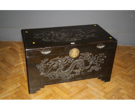 A Chinese carved teak and camphor wood trunk with rampaging dragon motif, 107cm wide