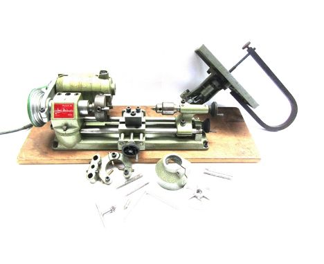 An Emco-Unimat Model SL centre lathe with jigsaw and attachments including 4-jaw chuck, faceplate, steady rest, some cutting 