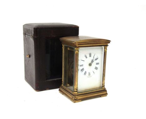 An early 20th Century carriage timepiece, Roman enamelled dial, brass architectural form case, with integral key and leather 