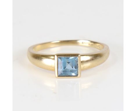 A modern 9ct gold blue topaz dress ring, set with square step cut topaz, setting height 6.3mm, size P, 2.7gNo damage or repai