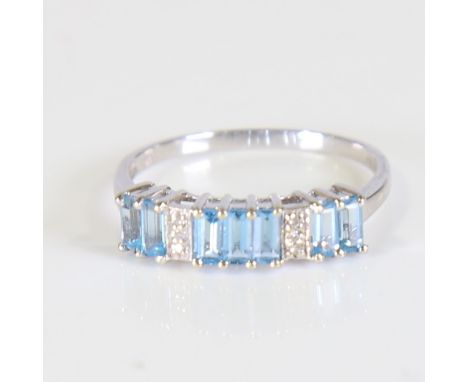 A modern 9ct white gold blue topaz and diamond half hoop ring, set with baguette cut topaz and eight cut diamonds, setting he