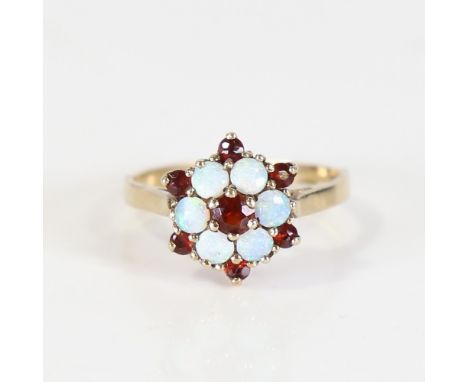 A modern 9ct gold opal and garnet cluster ring, set with circular cabochon opals and round cut garnets, setting height 12.5mm