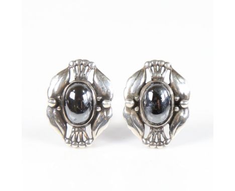 GEORG JENSEN - a Vintage Danish pair of clip earrings of the year 2000, openwork stylised sterling silver settings with caboc