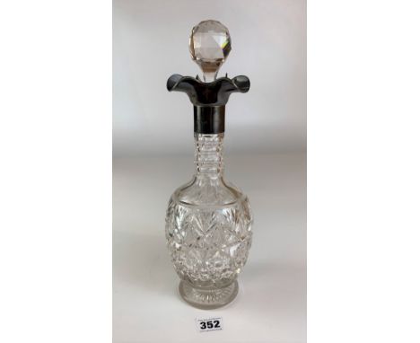 Silver topped cut glass decanter with stopper. Height 13.5” inc. Stopper. Good condition