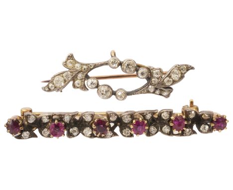 A ruby and diamond bar brooch, the six circular-cut rubies  with diamond-set foliate detail between (one diamond deficient), 