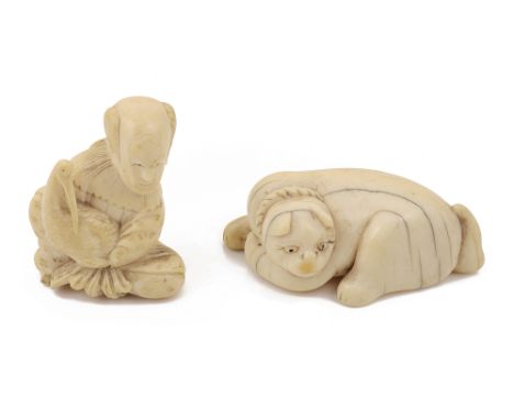 A Japanese ivory netsuke19th century, in the form of a recumbent cat, together with a netsuke in the form of a scholar holdin