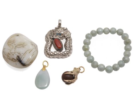 A contemporary carved jade boulder pendant and other itemsincluding a yellow metal mounted gold stone claw pendant tests gold