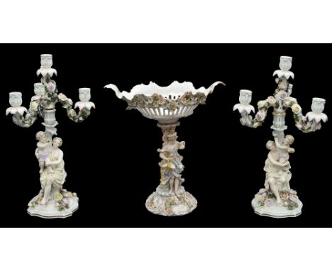 A pair of late 19th century Sitzendorf porcelain flower encrusted figural four light candelabraeach modelled as a seated clas