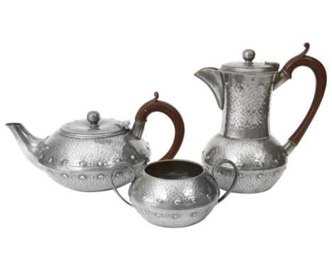 An Arts and Crafts pewter three piece tea service stamped W &amp; Co., Homleandof circular compressed form with riveted effec