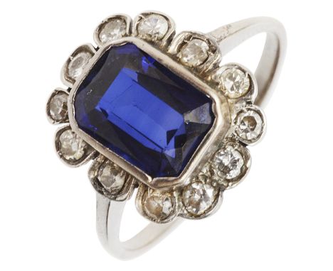 A blue stone and diamond-set cluster ring, the rectangular cut-cornered blue stoner (probably a synthetic sapphire) collet-se