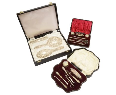 A modern cased silver four piece dressing table set and two cased silver mounted manicure setsfirst Birmingham, 1983 by by W 