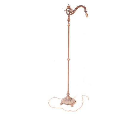 An early 20th Century brass Art Nouveau floor standing lamp light. With scrolled ornate detail arm, on a reeded central colum