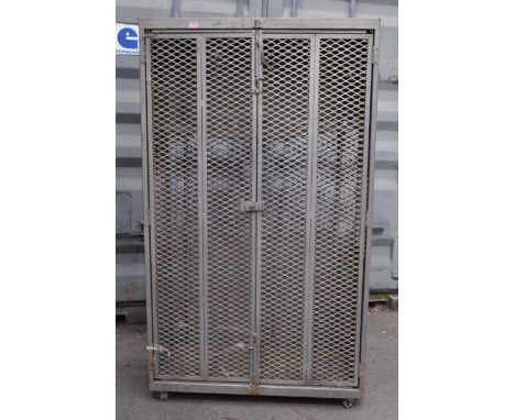 A 20th Century retro industrial metal storage two door locker cage raised on castor wheels. Of rectangular form having grey c