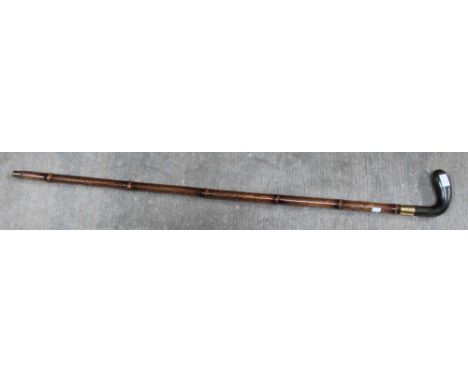 An early 20th century walking stick, having carved horn golf club handle, cane shaft, with gold plated band, engraved "B.G.C 
