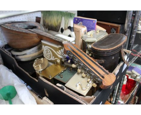 A box containing binoculars, clocks, wooden cow ornament, mother of pearl inlaid banjo
