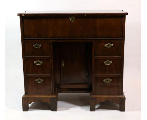 A George II Walnut and Rosewood Crossbanded Kneehole Desk, 2nd quarter 18th century, the hinged lid with re-entrant corners e