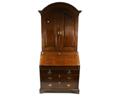 A George III Oak Bureau Bookcase, 3rd quarter 18th century, the moulded architectural pediment above panelled doors enclosing