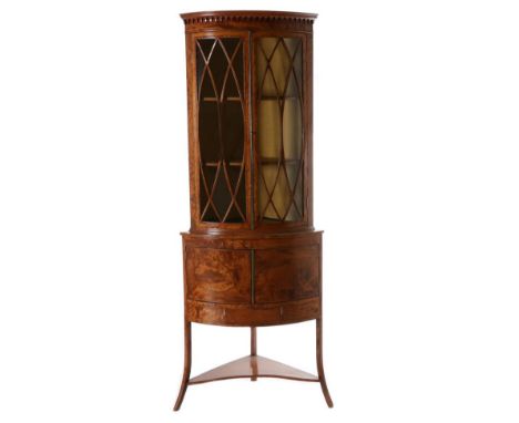 A George III Satinwood and Ebony Strung Free-Standing Corner Cupboard, the arcaded cornice above glazed doors enclosing two s