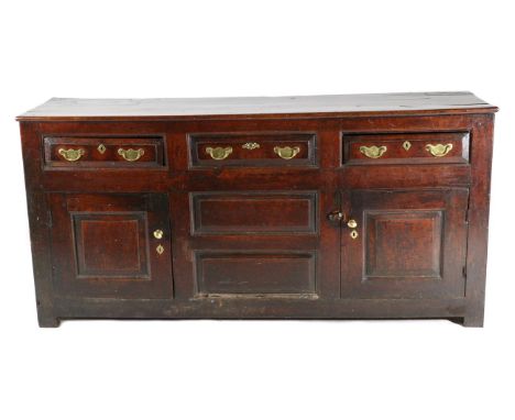 An Early 18th Century Oak Enclosed Dresser, with three frieze drawers above two fielded panels flanked by cupboard doors, 185