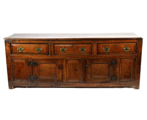 An Early 18th Century Oak Enclosed Low Dresser, the moulded top above three long drawers, the base with two cupboard doors fl
