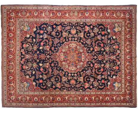 Kashan Carpet Central Iran, circa 1930 The indigo field of scrolling vines around a cusped pole medallion framed by spandrels