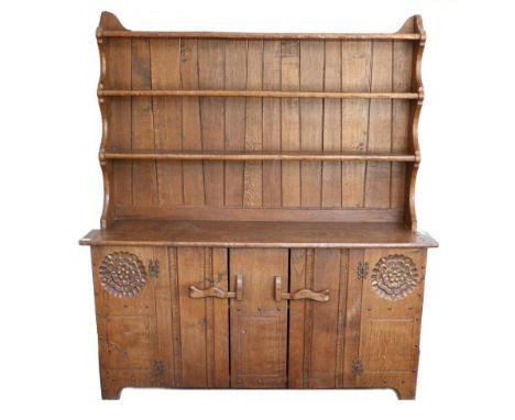 A Jack Grimble of Cromer Oak Dresser, the plate rack above two cupboard doors, with exposed pegged construction and carved ro