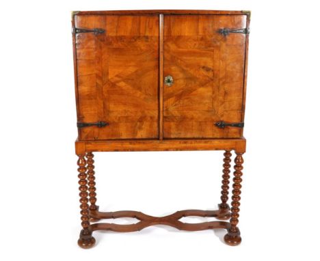 A George I Walnut and Crossbanded Cabinet on Stand, with two cupboard doors crossbanded and veneered in the form of a lozenge