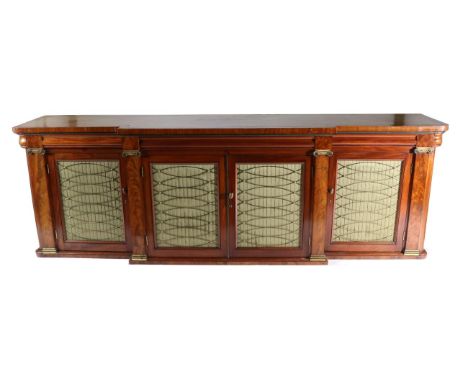 A Mahogany Breakfront Cabinet, circa 1820/30, with three moulded frieze drawers above brass and gathered silk lined doors, al