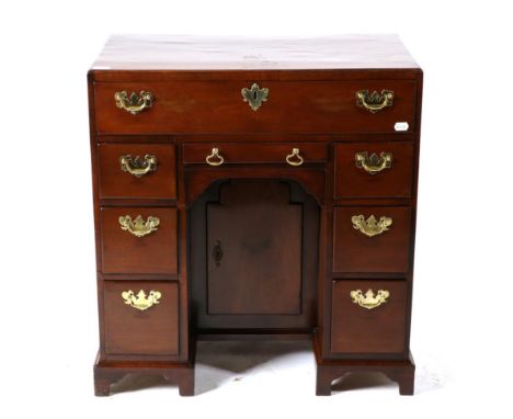 A George II Mahogany Kneehole Desk, mid 18th century, with a long drawer above six graduated drawers and a narrow drawer all 