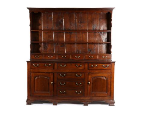 A George III Oak Enclosed Dresser, early 19th century, the rack with arched apron above two fixed shelves and six small drawe
