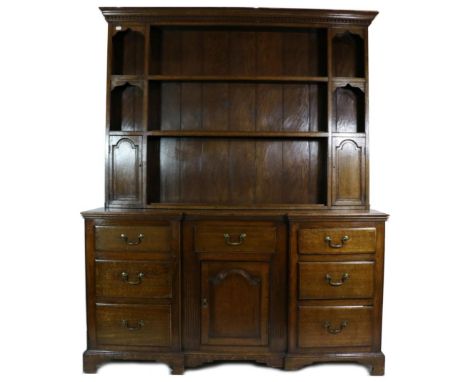 A George III Oak Enclosed Dresser, early 19th century, the rack with a dentil cornice above two shelves and small niches abov