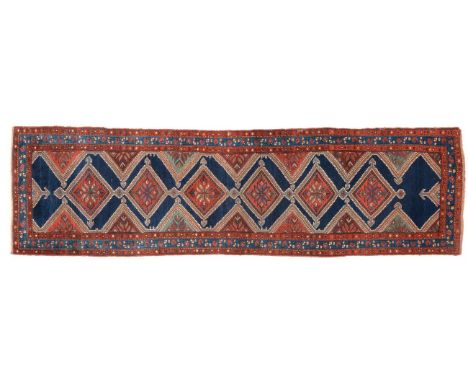 Luri Runner West Iran, circa 1920 The Indigo field with a column of stepped medallions framed by triple borders, 424cm by 116