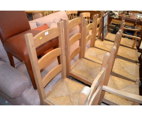 A pair of oak and rush seated dining chairs; and a leather dining chair