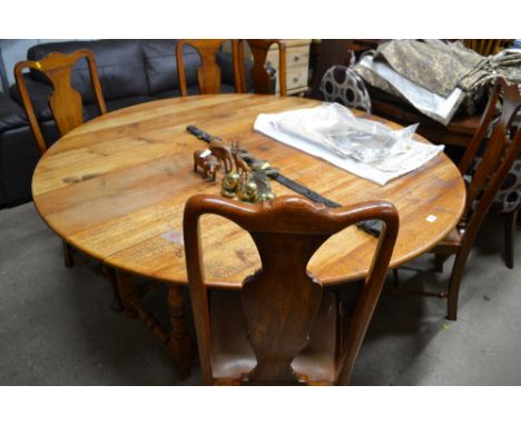 An oak gate leg dining table with a set of five Queen Anne style chairs 