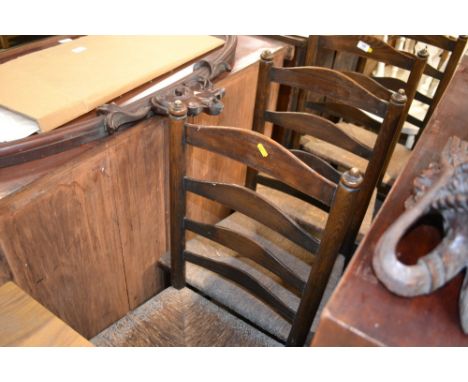 A set of four oak ladder back and rush seated dining chairs 