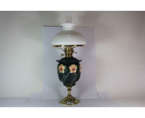 A lovely brass and ceramic oil lamp with glass reservoir, H. 64cm.